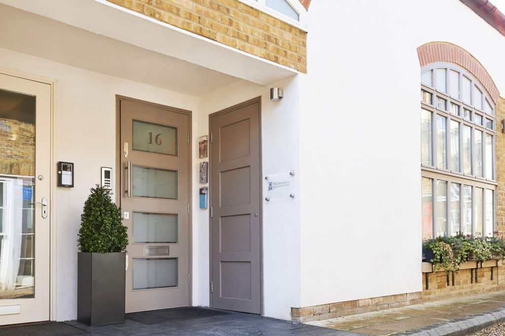 Clinic entrance with door and address number 16 in a modern building.